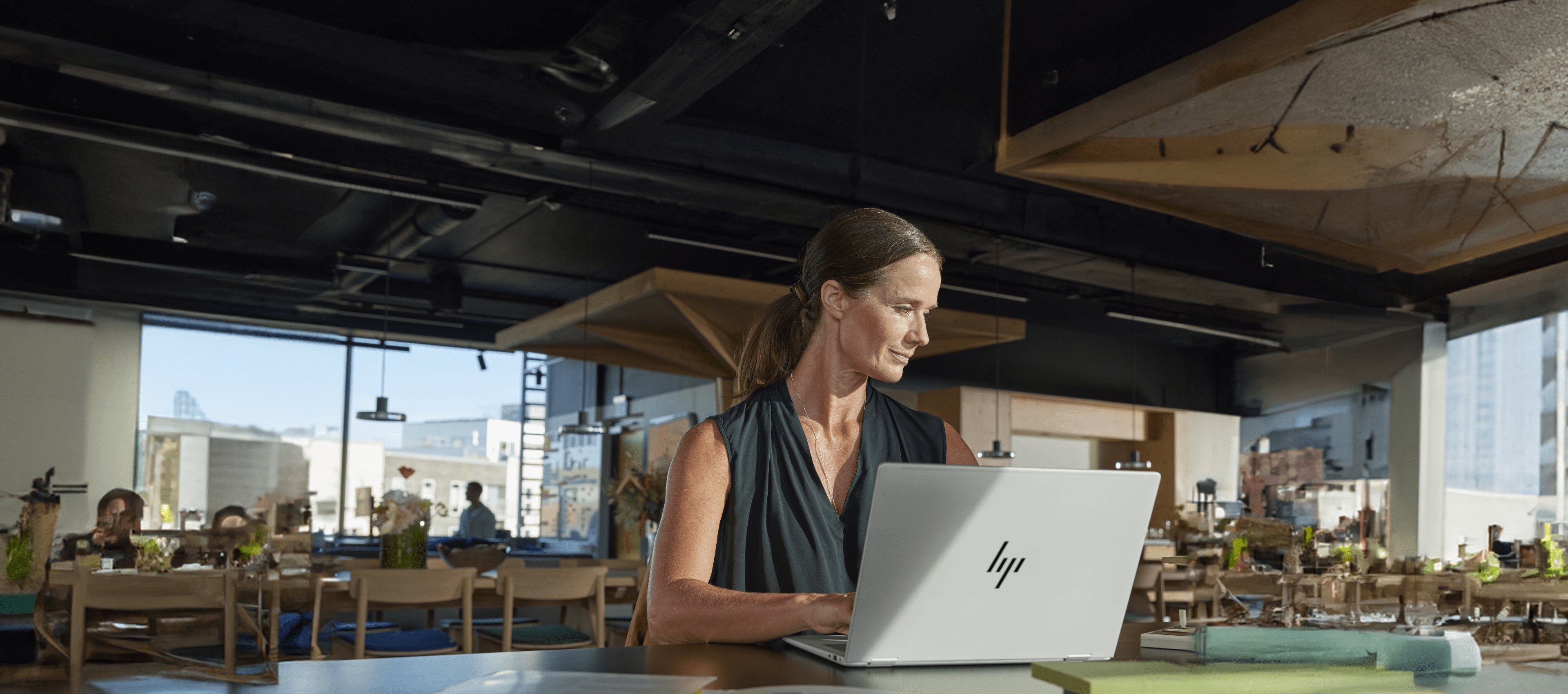 Woman working on HP laptop in open workspace